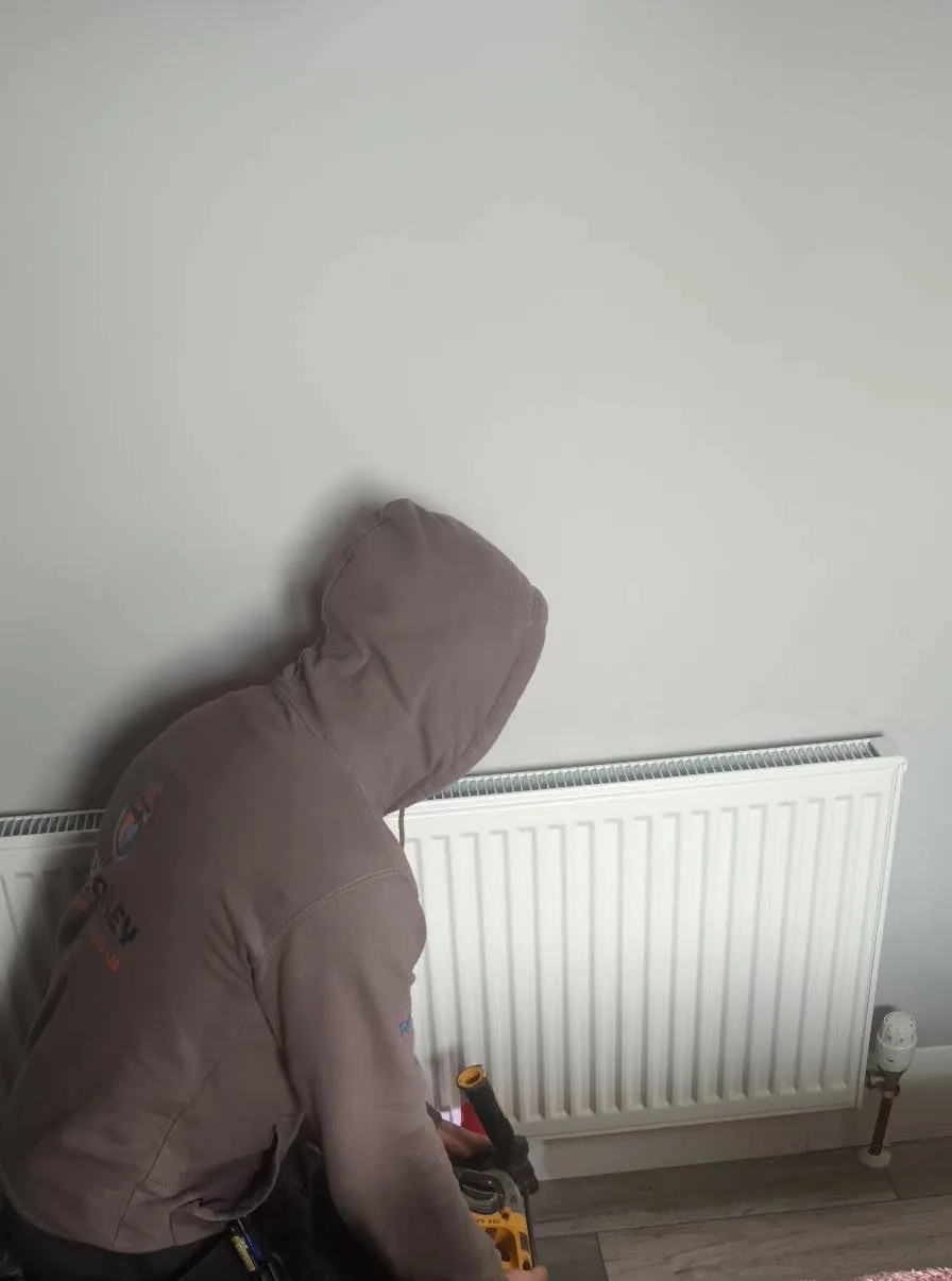 New radiator being fitted to a wall